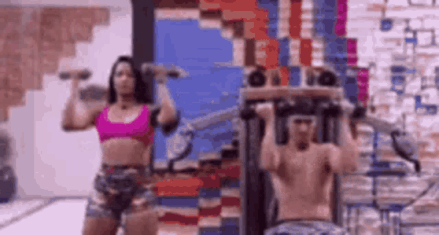 a man and a woman are working out in a gym .