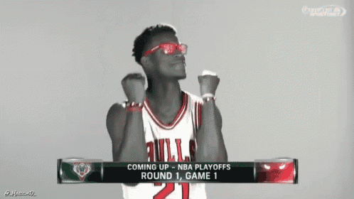 a man wearing sunglasses and a bulls jersey is celebrating