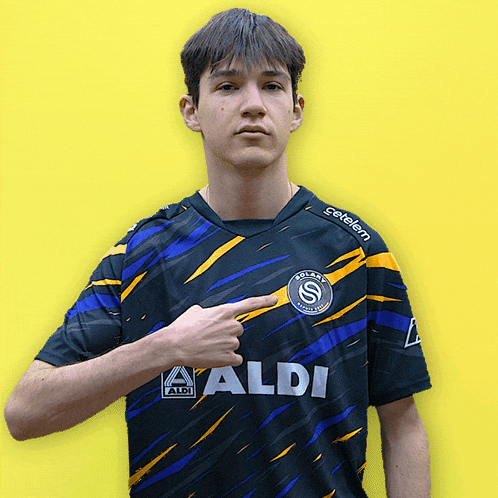 a young man wearing a black and blue shirt that says aldi on it