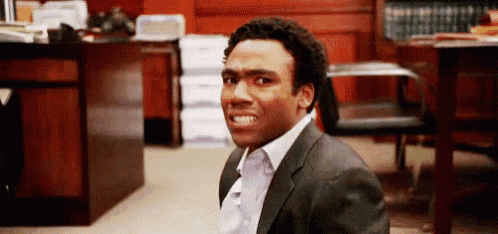 a man in a suit is making a funny face in a room .