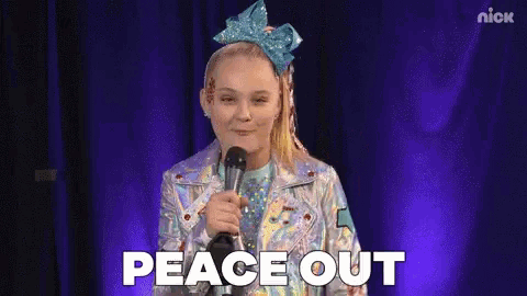 a girl with a bow in her hair is holding a microphone and saying `` peace out '' .