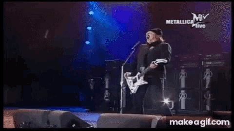 a man is playing a guitar and singing into a microphone while standing on a stage .