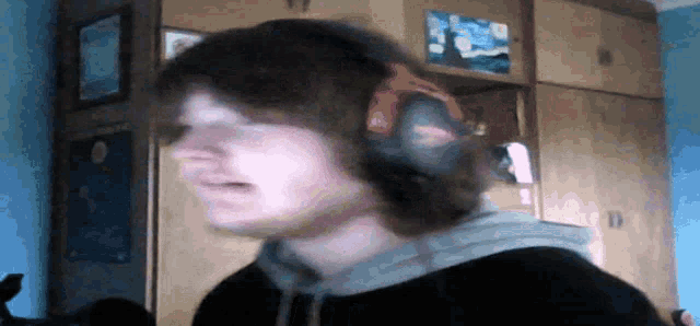 a man wearing headphones stands in a room