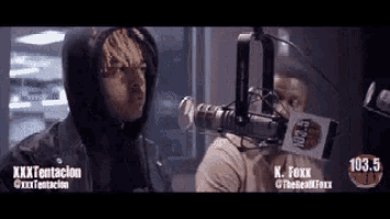 a man in a hoodie is talking into a microphone at 103.5 fm radio