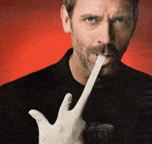 a man with a beard is holding a white glove in his mouth