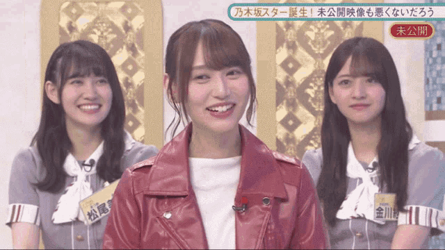 a woman wearing a red leather jacket smiles in front of three other women