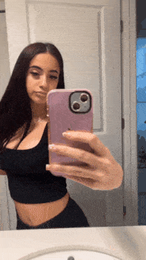 a woman is taking a selfie with her phone in a pink case
