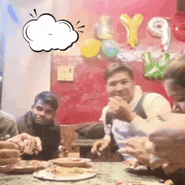 a group of people are sitting at a table with plates of food and balloons that say y9 on them