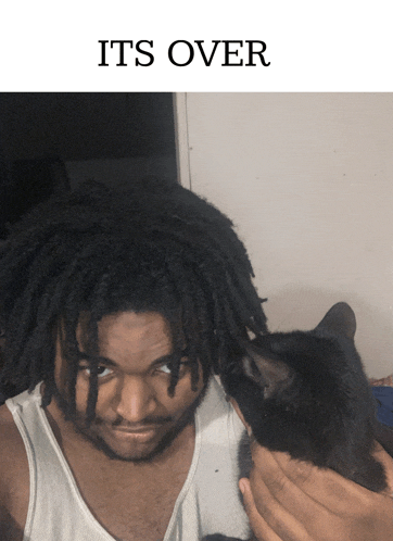 a man with dreadlocks is holding a black cat with the words its over below him