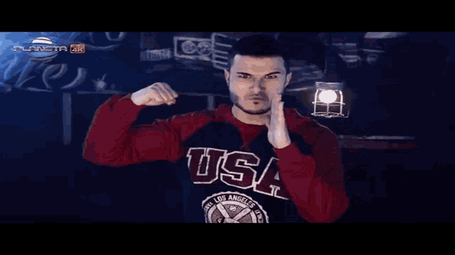 a man flexes his muscles in front of a sign that says planeta 4k