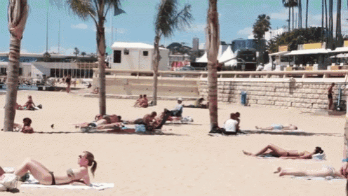 a woman in a bikini is laying on a beach towel