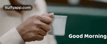 a man is holding a cup of coffee with the words `` good morning '' written on it .