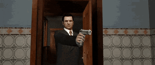a man in a suit and tie holds a gun in front of a door