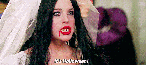 a woman in a vampire costume is talking about halloween .