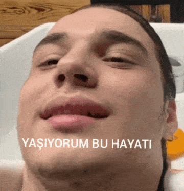 a close up of a man 's face with the words " yaşiyorum bu hayati " on the bottom right