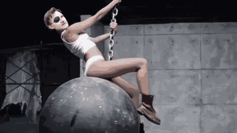 a woman in underwear is sitting on top of a large ball .