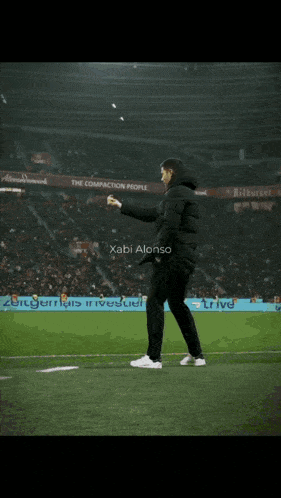 a man walking on a soccer field with the name xabi alonso written on the bottom
