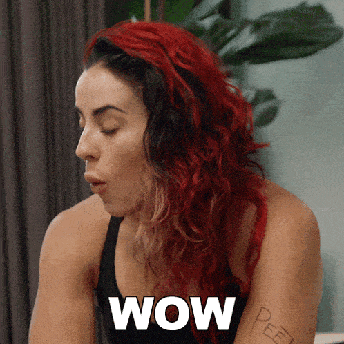a woman with red hair and the word wow on her arm