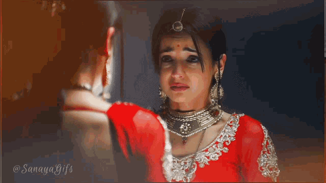 a woman in a red dress is crying while another woman wipes her eyes