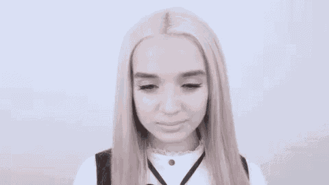 a close up of a woman 's face with blonde hair making a funny face .