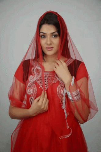 a woman in a red dress has a veil over her head