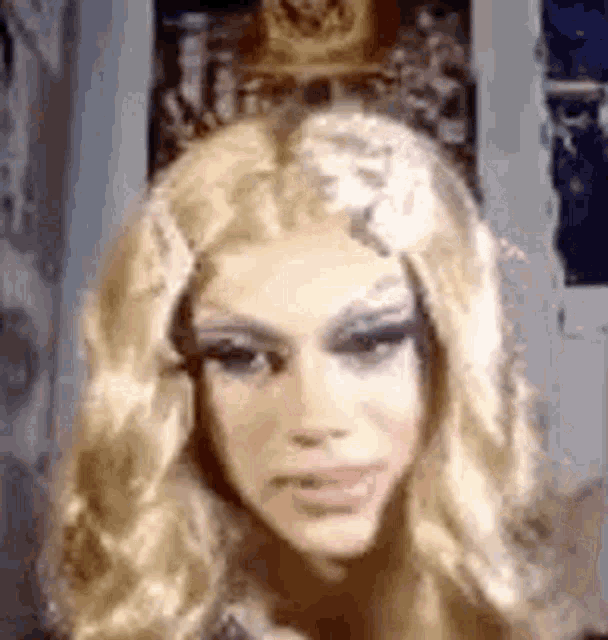 a close up of a woman wearing a blonde wig making a funny face .