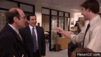 three men in suits and ties are standing next to each other in an office talking to each other .