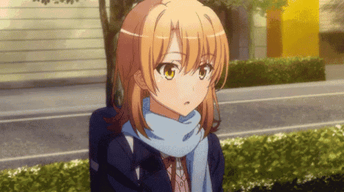 a girl wearing a scarf and a jacket is standing in front of a building .