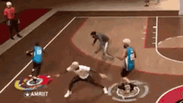 a group of people are playing basketball on a court . one of the players has the number 28 on his jersey .