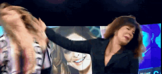 a woman is dancing in front of a screen that says ao vivo on it