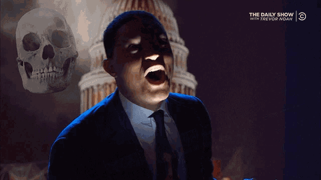 a man in a suit and tie screams in front of a skull and the daily show logo