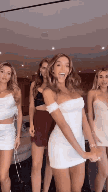 a group of women are standing next to each other in a room .