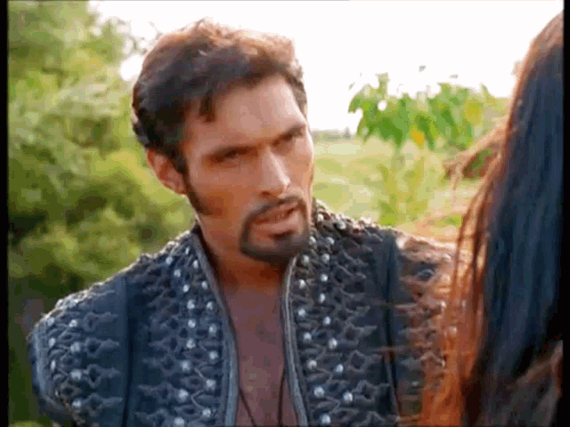a man with a beard is talking to a woman with long hair .