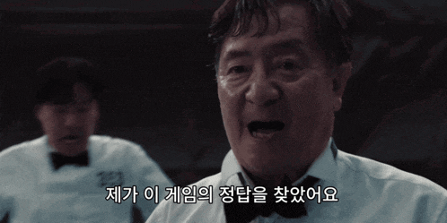 a man in a white shirt and bow tie is speaking in korean