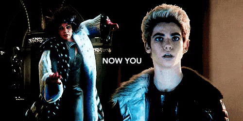 a man in a fur coat is standing in front of a sign that says " now you "