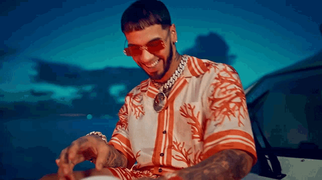 a man wearing sunglasses and a shirt with coral on it