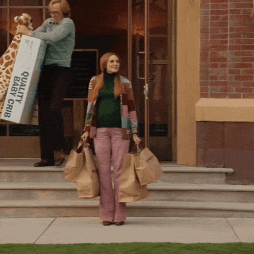 a woman is carrying a box that says quality baby crib on it