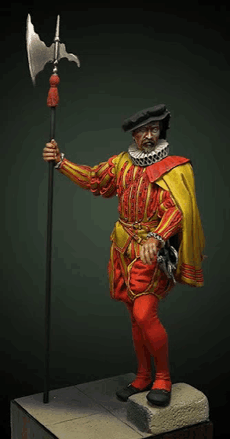 a statue of a man in a yellow and red outfit holding a large axe