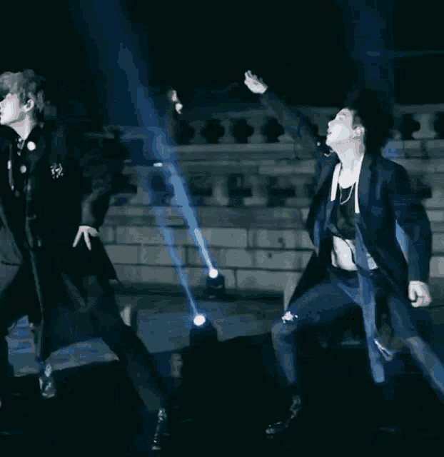 a man in a suit is dancing with his arms outstretched