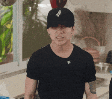 a man wearing a black shirt and a black hat