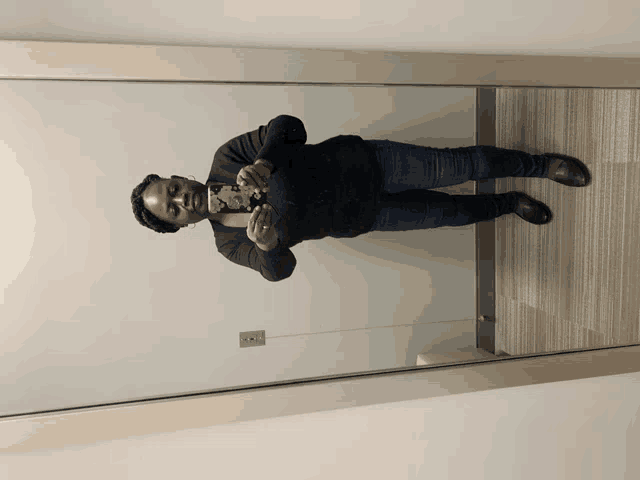 a woman taking a picture of herself in the mirror