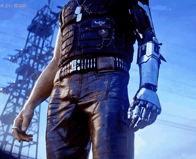 a man with a robotic arm is standing in front of a power tower with the time 21.22.0003 on the screen