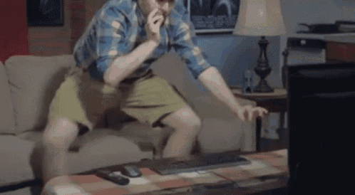 a man is sitting on a couch in front of a computer screen .