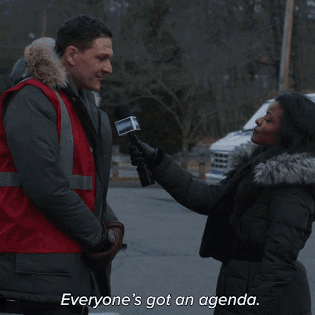 a man is being interviewed by a woman with the words everyone 's got an agenda on the bottom