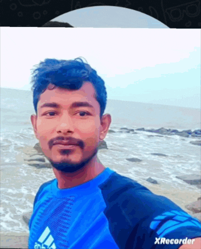 a man wearing a blue adidas shirt takes a selfie