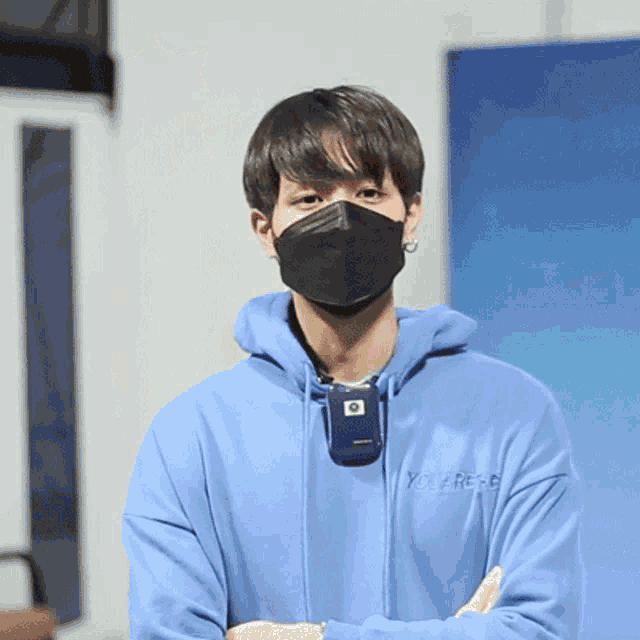 a man wearing a mask and a blue sweatshirt that says you are free