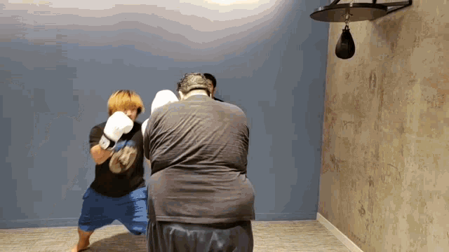 a man wearing boxing gloves is standing next to another man