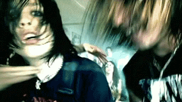 a man and a woman are standing next to each other and the woman is wearing a shirt that says nirvana