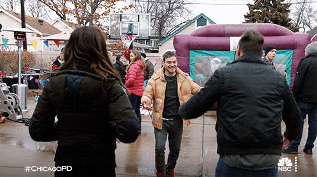 a group of people are dancing in front of a bouncy house with the hashtag #chicagopd on the bottom
