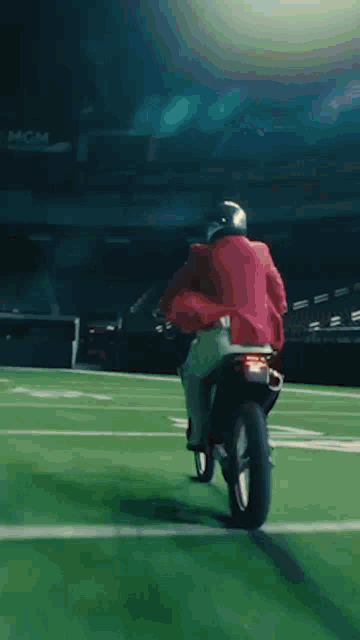 a man is riding a motorcycle down a road at night